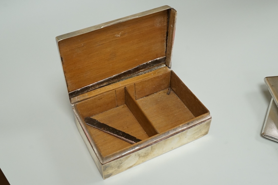 An engine turned silver rectangular cigarette box, 14.1cm and two mid 20th century engine turned silver cigarette cases.